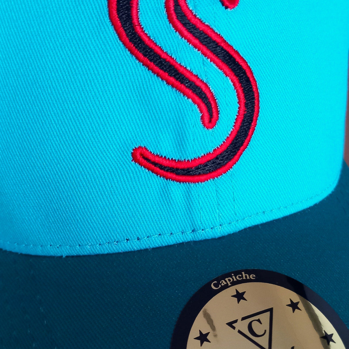 Close up of the red snake logo from the Fire Snake curved cap from Capiche