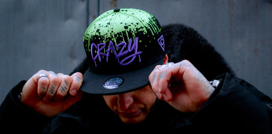 Casquettes Capiche Caps pour le Nouvel An, ornées d'un motif graffiti audacieux sur une fermeture snapback noire, pour un look streetwear urbain et une célébration de fin d'année réussie.