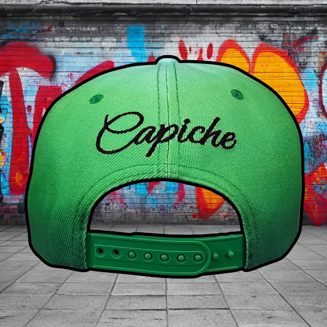 Green cap with 'Capiche' text against a graffiti-covered wall.