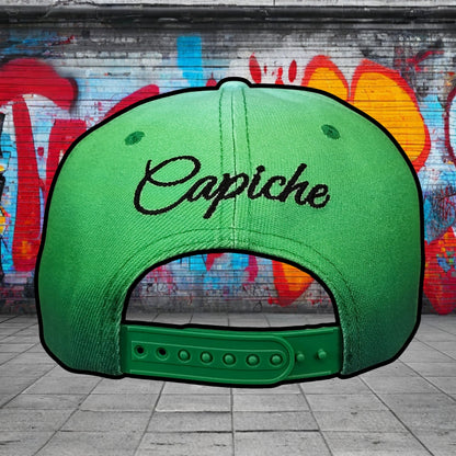 Green cap with 'Capiche' text against a graffiti-covered wall.