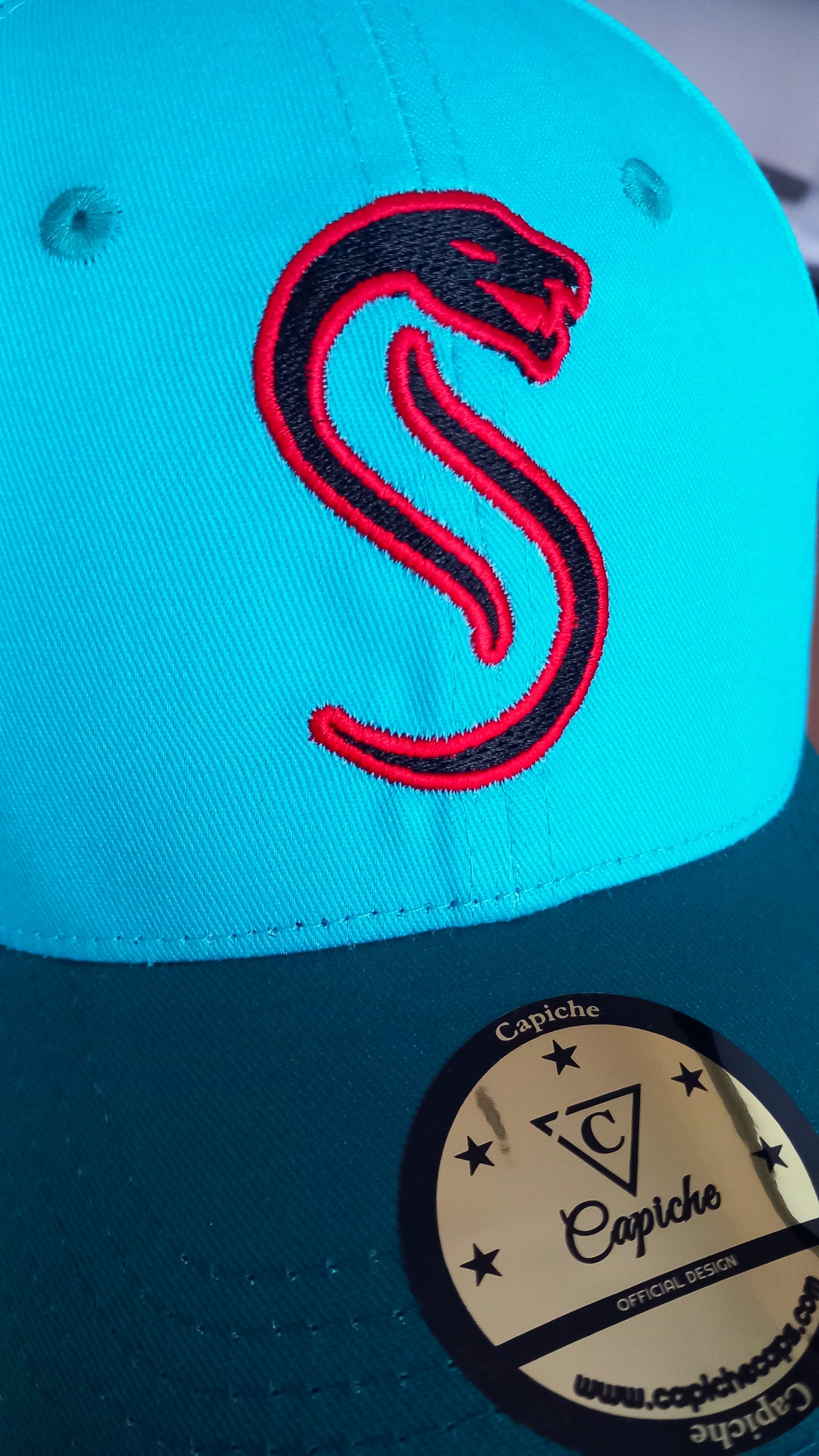 Close up of the red snake logo from the Fire Snake curved cap from Capiche