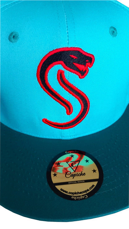 Close up from the red snake logo on a blue snapback from Capiche Caps