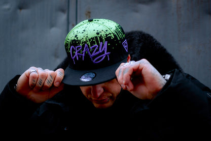 Tattoo model standing outside wearing a cool Capiche snapback hat from the Graffiti Collection